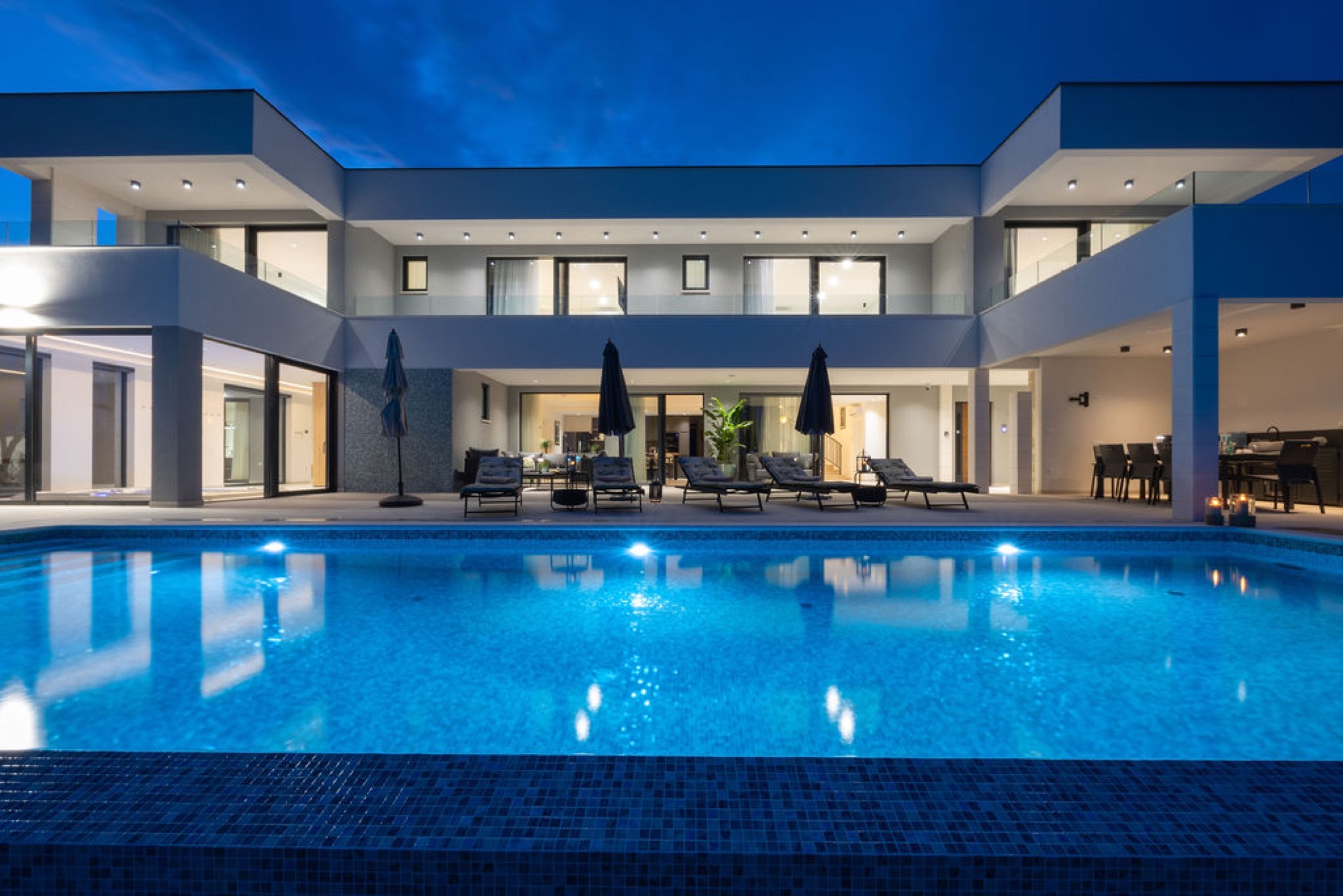 Blue Horizon villa at dusk with infinity pool overlooking the sea